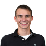Smiling man in black polo, transparent background, headshot.